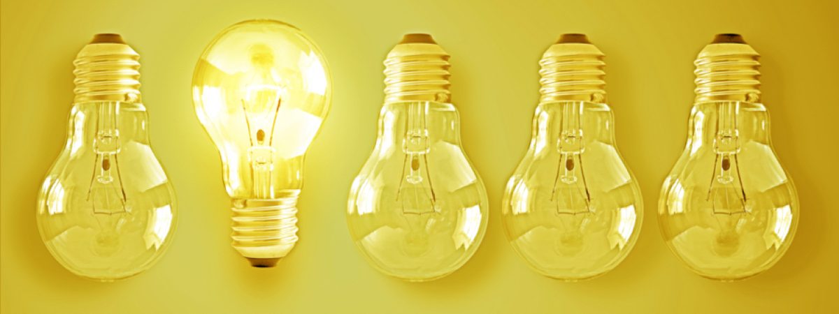 Illuminated light bulb in a row of dim ones concept for creativity, innovation and solution